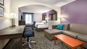 A hotel room with a bed, a sofa, a desk with a chair, and a TV. - La Quinta Inn by Wyndham North Myrtle Beach (North Myrtle Beach)
