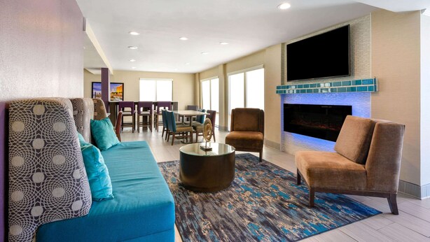 A spacious living room with a sofa, armchairs, a coffee table, and a fireplace. - La Quinta Inn by Wyndham North Myrtle Beach (North Myrtle Beach)