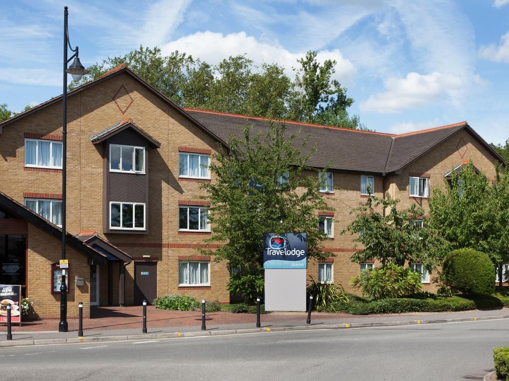 Un hôtel Travelodge avec une façade en briques, de nombreuses fenêtres et une enseigne.