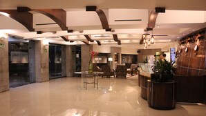 A modern lobby with a polished floor, seating area, and a reception desk.