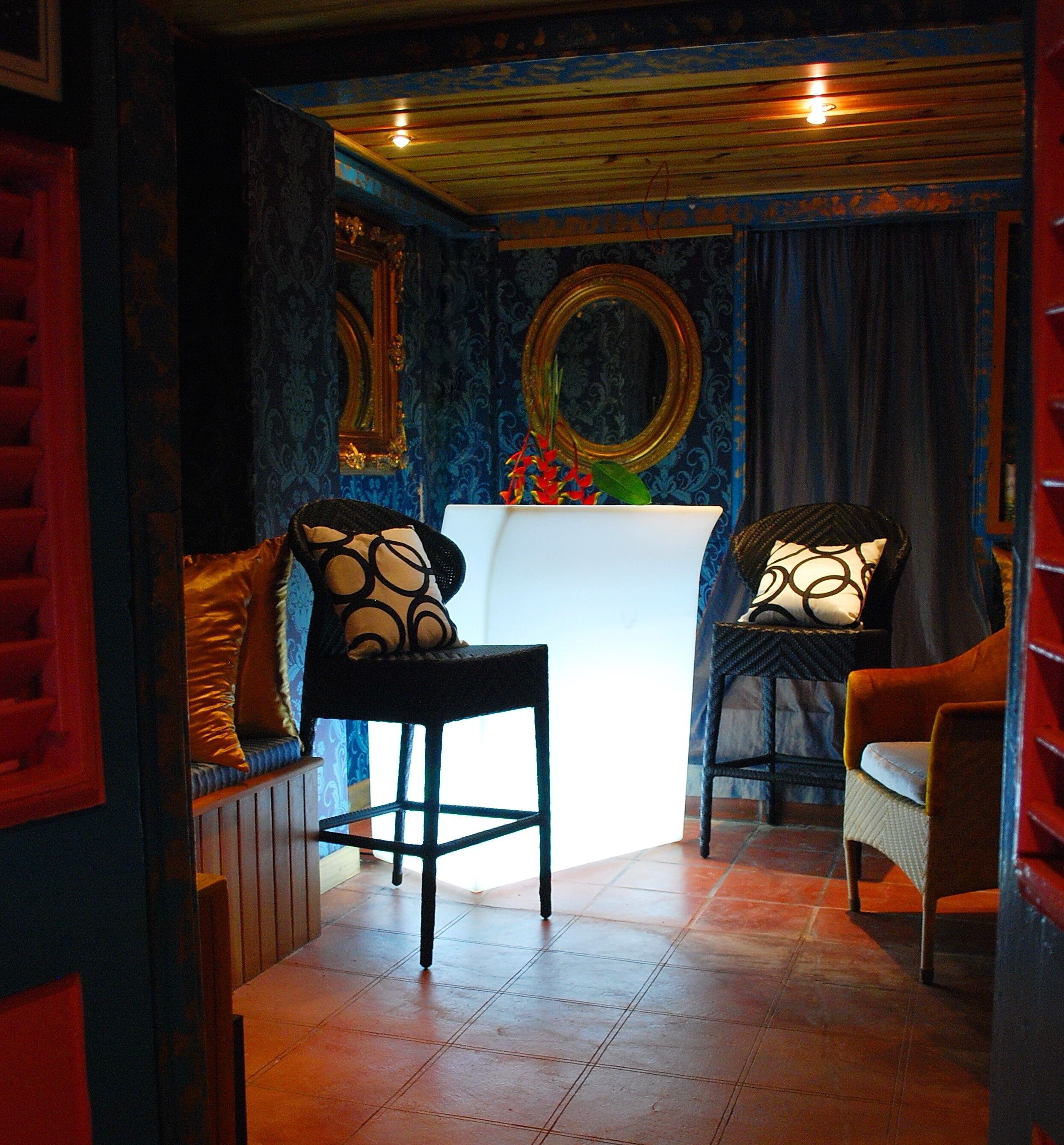 A room with a bar area, a mirror, and a patterned wall.