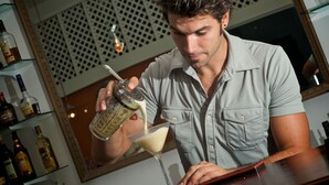 A person pouring a drink into a martini glass. - Half Moon Blue (Scarborough)