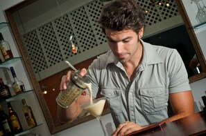 Une personne qui verse une boisson dans un verre à martini.