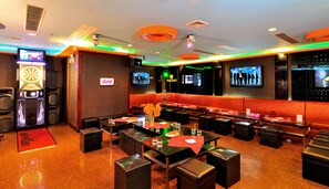 Un restaurant avec des banquettes, des tables et un jeu de fléchettes.