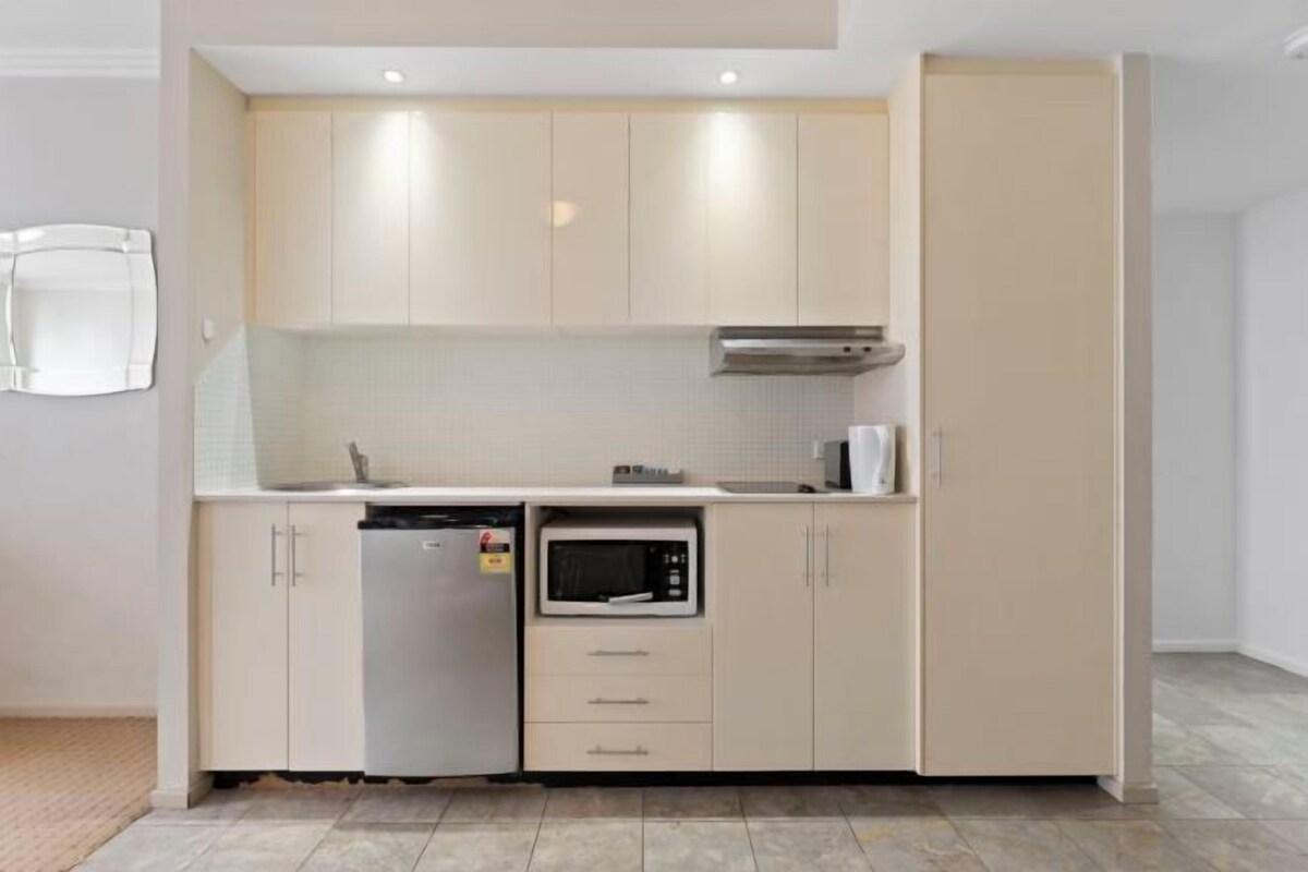 Uma cozinha compacta equipada com lava-louças, micro-ondas e forno embutido.