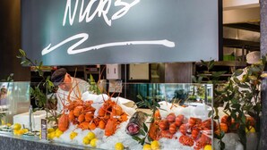 A seafood display with various types of seafood on ice, including lobsters and shrimp, in a restaurant setting. - APX Darling Harbour (Sydney)