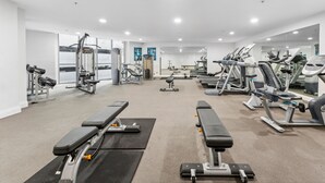 A modern gym with various exercise equipment, including treadmills, weight machines, and benches. - APX Darling Harbour (Sydney)