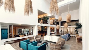 A spacious lobby with high ceilings, hanging woven light fixtures, and a variety of seating options including sofas and chairs. - The Views Oasis - Family Friendly (Santa Cruz)