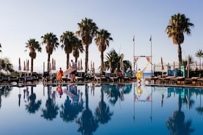 Piscine extérieure, parasols de plage, chaises longues