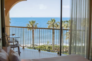 A balcony with a view of the sea, palm trees, and a chair. - The Views Oasis - Family Friendly (Santa Cruz)