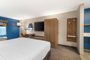 A hotel room with a bed, desk, chair, TV, wardrobe, and a small shelf. - Holiday Inn Express Biddeford by IHG (Biddeford)