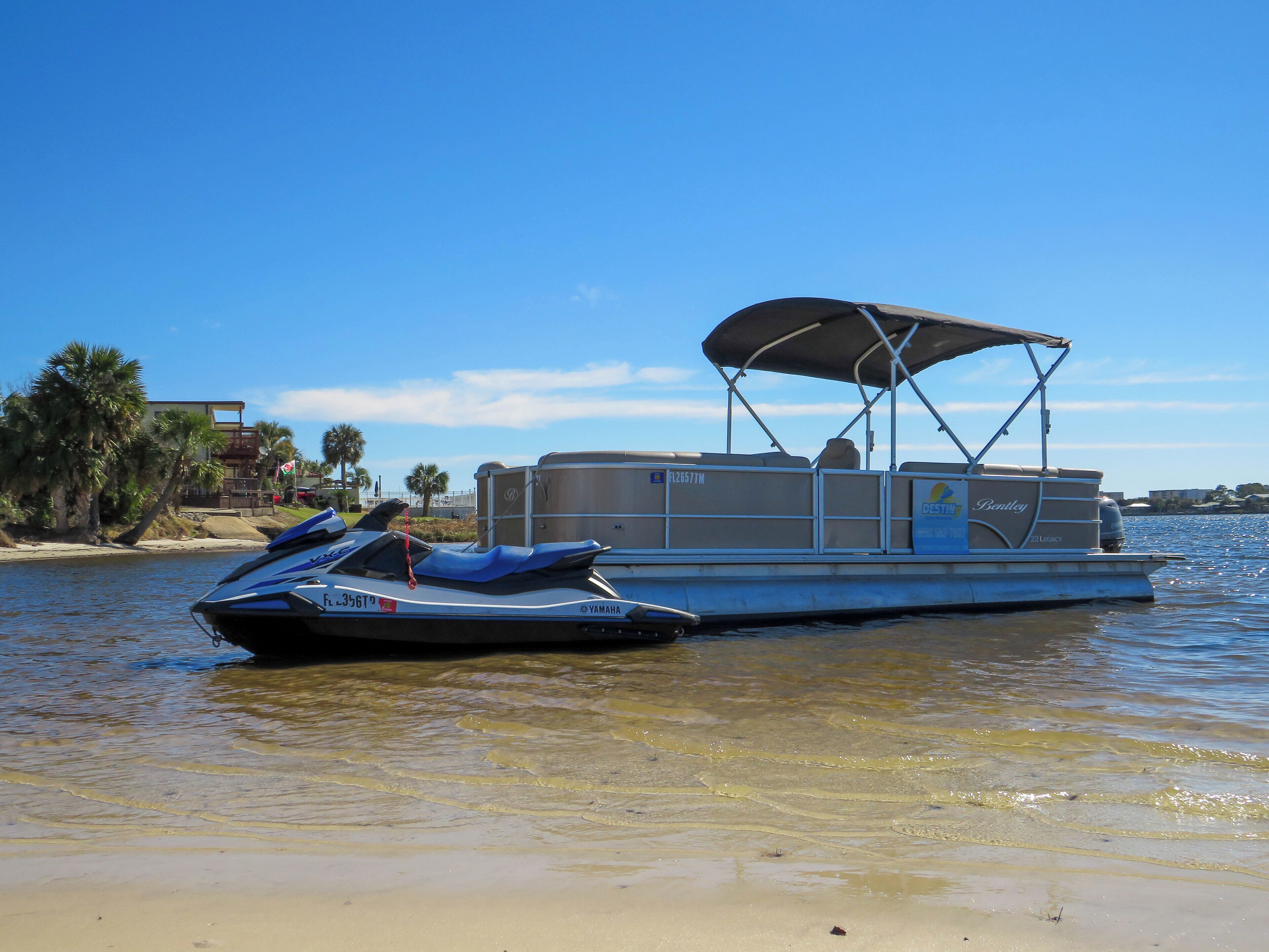 A pontoon boat with a covered seating area and a Yamaha outboard motor.