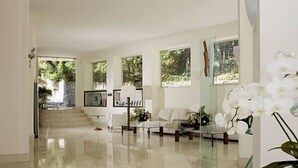 Amplia sala de estar con sofá, mesa de centro y un separador de vidrio.