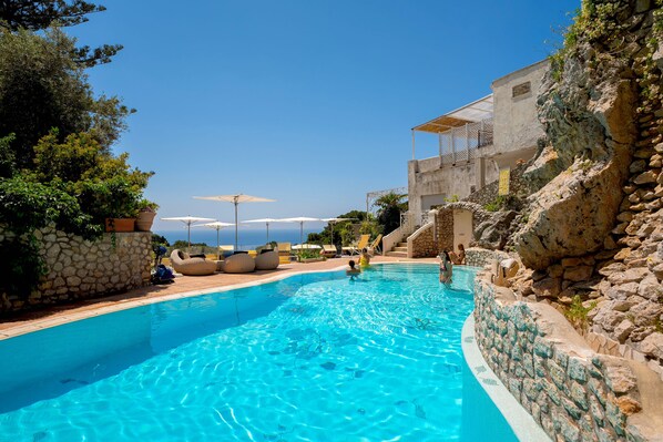 Una piscina al aire libre de temporada, sombrillas