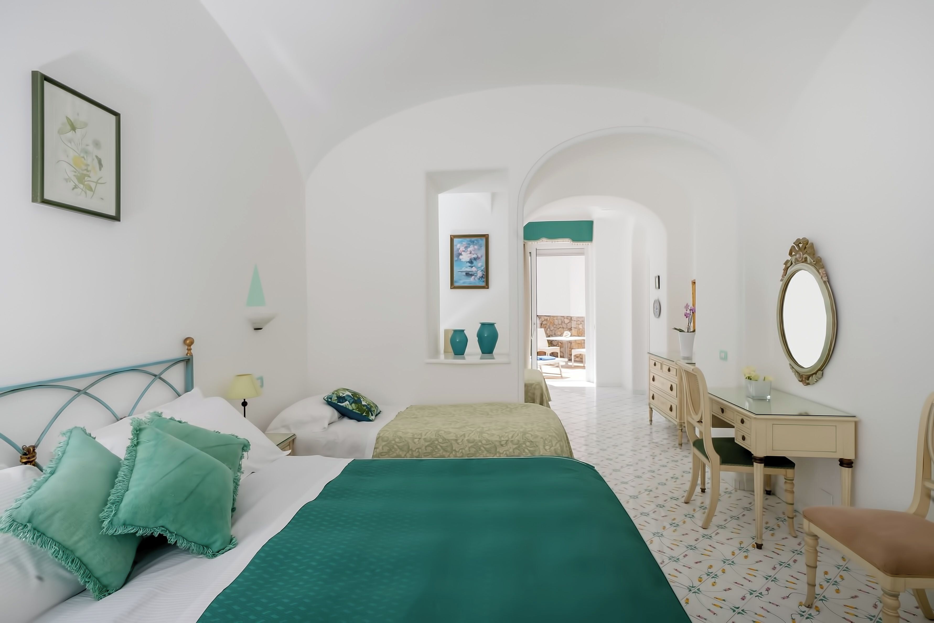Un dormitorio con cama, escritorio y espejo.