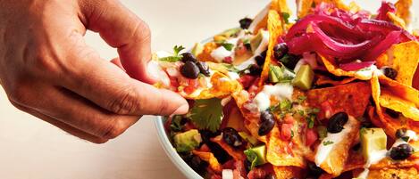 A bowl of nachos with various toppings.