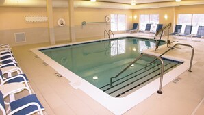 Ein Hallenbad mit deutlich abgegrenzten Bahnen, Rettungsschwimmerstühlen und Sicherheitsgeländern.