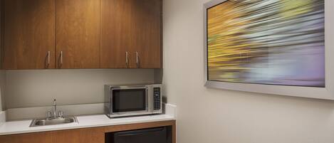 A kitchen with wooden cabinets, a stainless steel sink, a microwave, and a dishwasher.