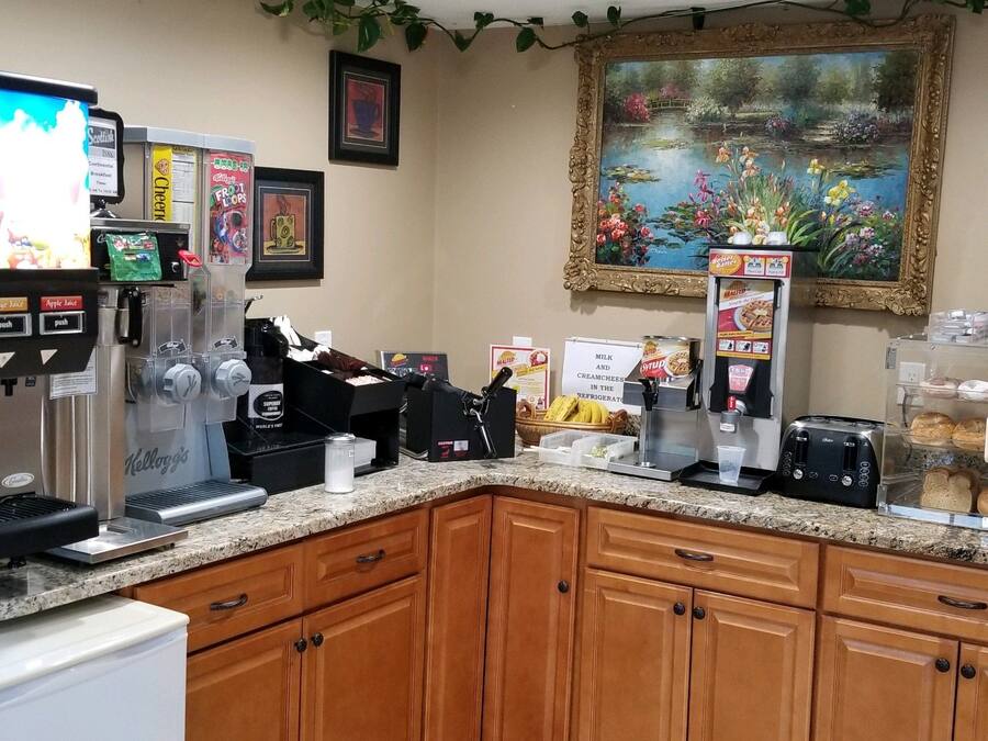 A coffee station with a coffee machine, a milk frother, and a display of coffee cups.