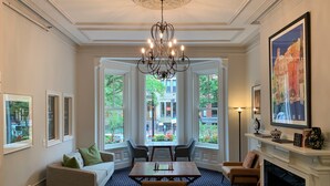 A room with a chandelier, a fireplace, a dining table, and a sofa. - Newbury Guest House (Boston)