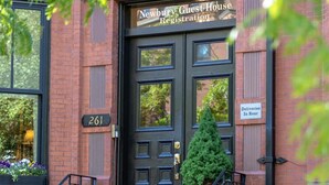 A brick building with a black door labeled "Newbury Guest House Registration." - Newbury Guest House (Boston)