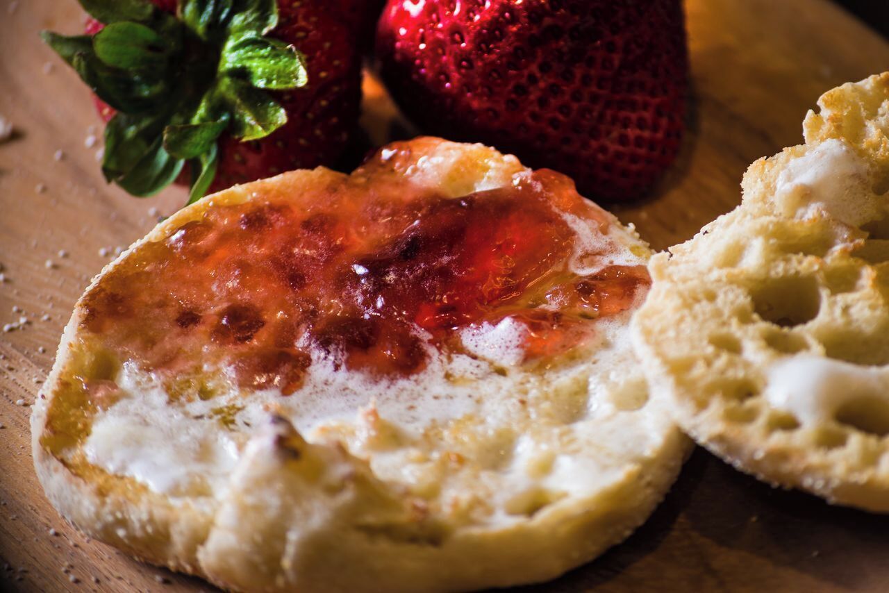 Una tostada con mermelada y una fresa.