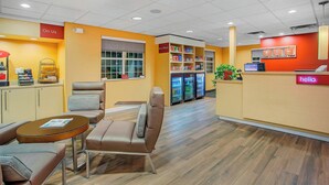 A hotel lobby with seating areas, a reception desk, and a refrigerator stocked with beverages. - TownePlace Suites by Marriott Knoxville Cedar Bluff (Knoxville)