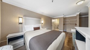 A hotel room with a large bed, bedside tables, a desk, and a walk-in closet. - Americas Best Value Inn San Clemente Beach (San Clemente)