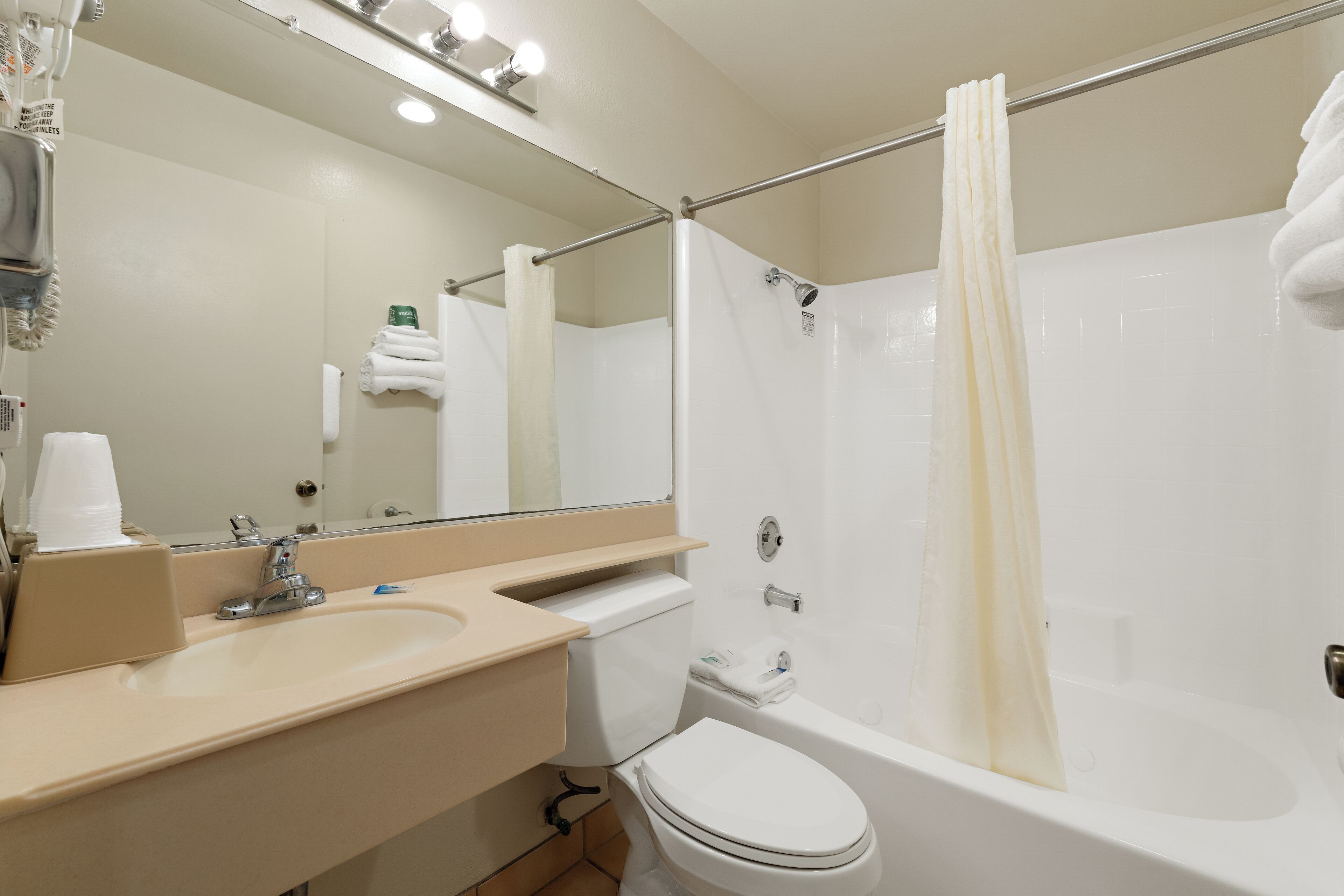 A modern bathroom with a sink, toilet, and bathtub.