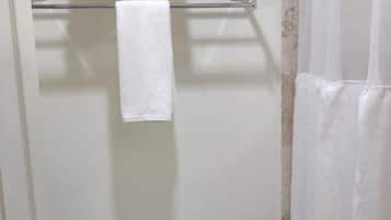 Un bagno piccolo e pulito con il water, un portasciugamani con due asciugamani e una tenda da doccia.