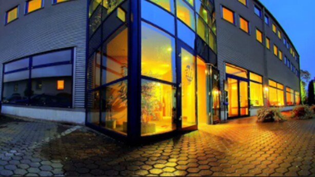 A modern building with large glass windows and a curved facade.