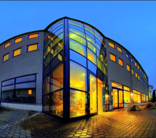 A modern building with large glass windows and a curved facade.
