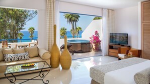 Una habitación de hotel moderna con balcón, sofá, televisión y una cama grande.
