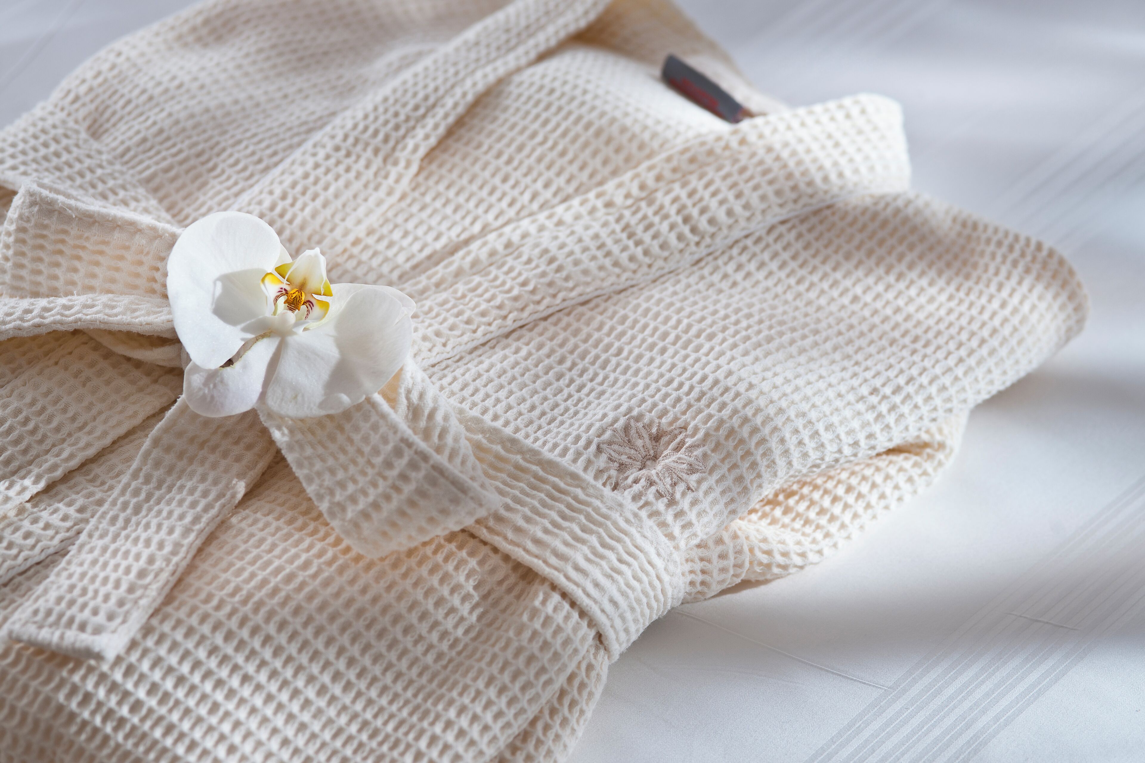 A white knitted garment with a floral decoration.