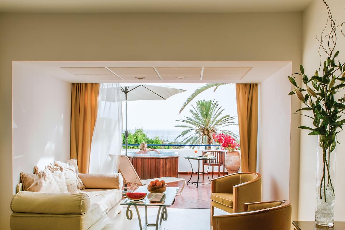 Una sala moderna con sofá, sillas, una mesa de centro y vistas al exterior.