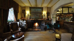 A cozy room with a fireplace, comfortable seating, and a bar area.