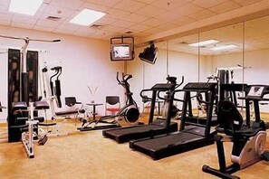 Un gimnasio con diferentes equipos de ejercicio, incluyendo cintas de correr y máquinas de pesas.