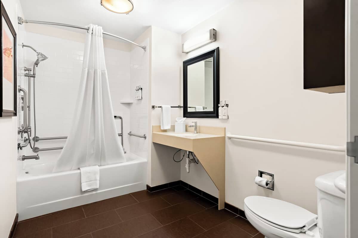 Une salle de bain moderne équipée d’une baignoire, d’une douche, de toilettes et d’un lavabo.