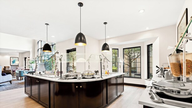 A modern kitchen with a central island, pendant lighting, and large windows. - Staybridge Suites Cincinnati North by IHG (West Chester)