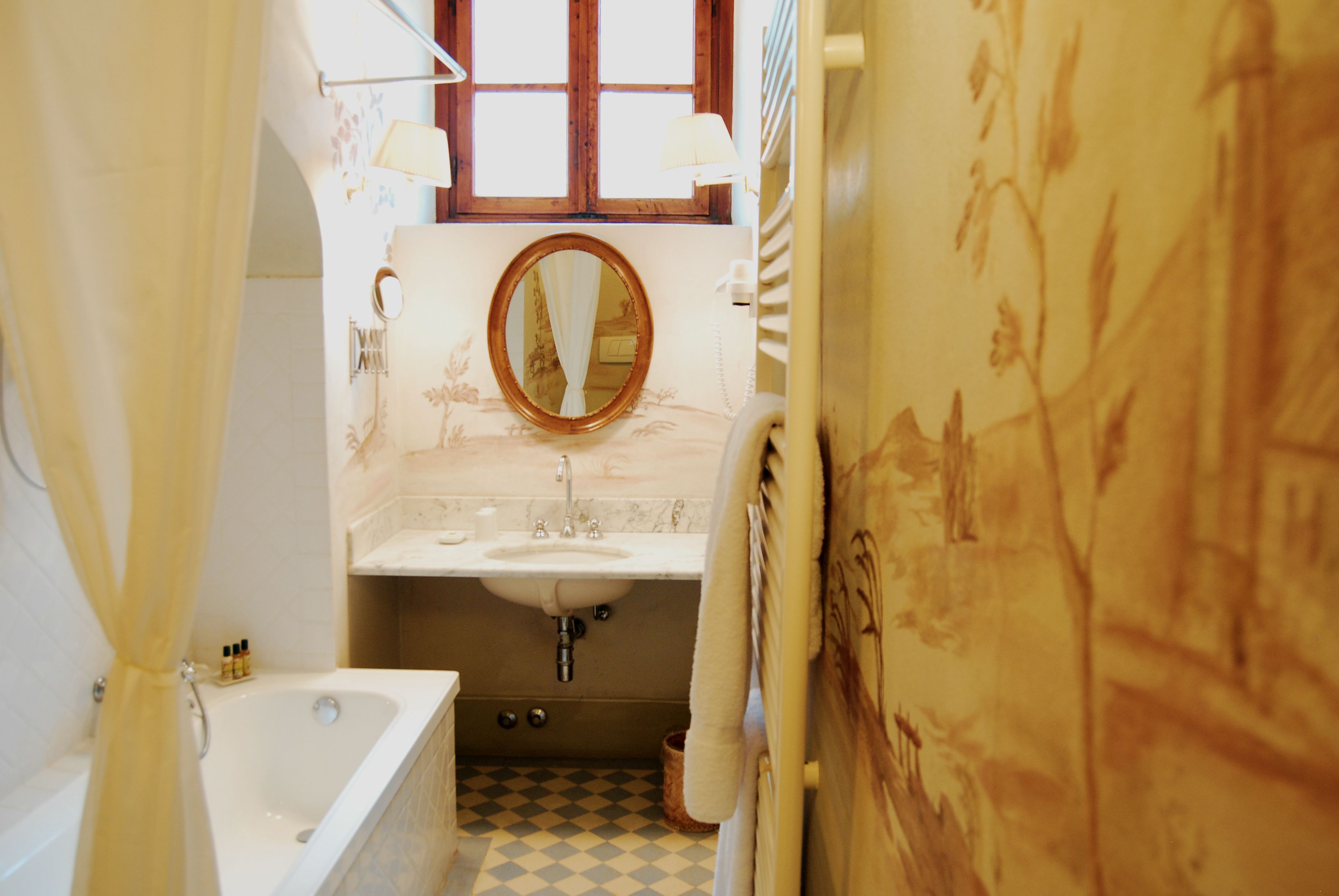 Un bagno stretto con vasca, lavandino e specchio.