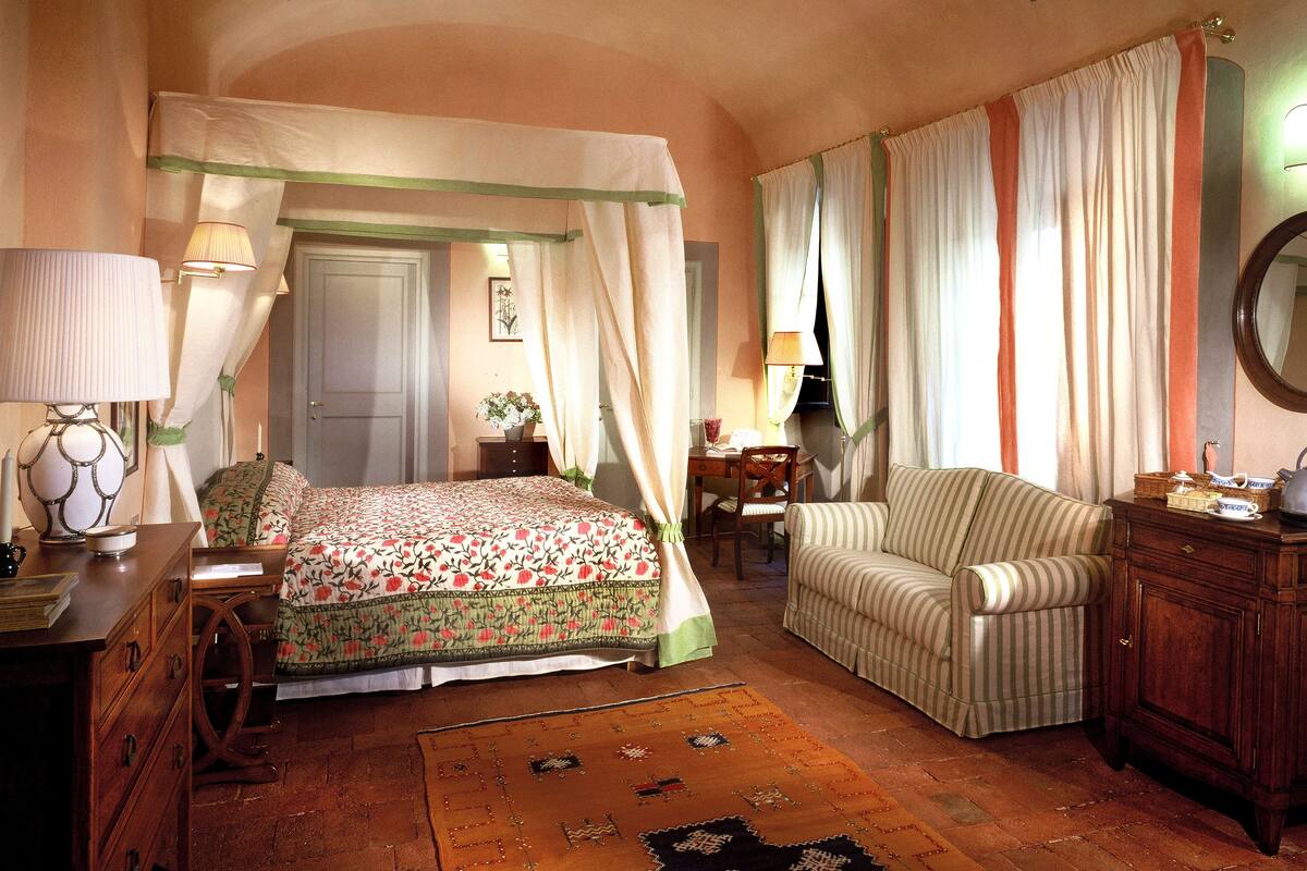 A bedroom with a bed, a chair, a dresser, and a nightstand.