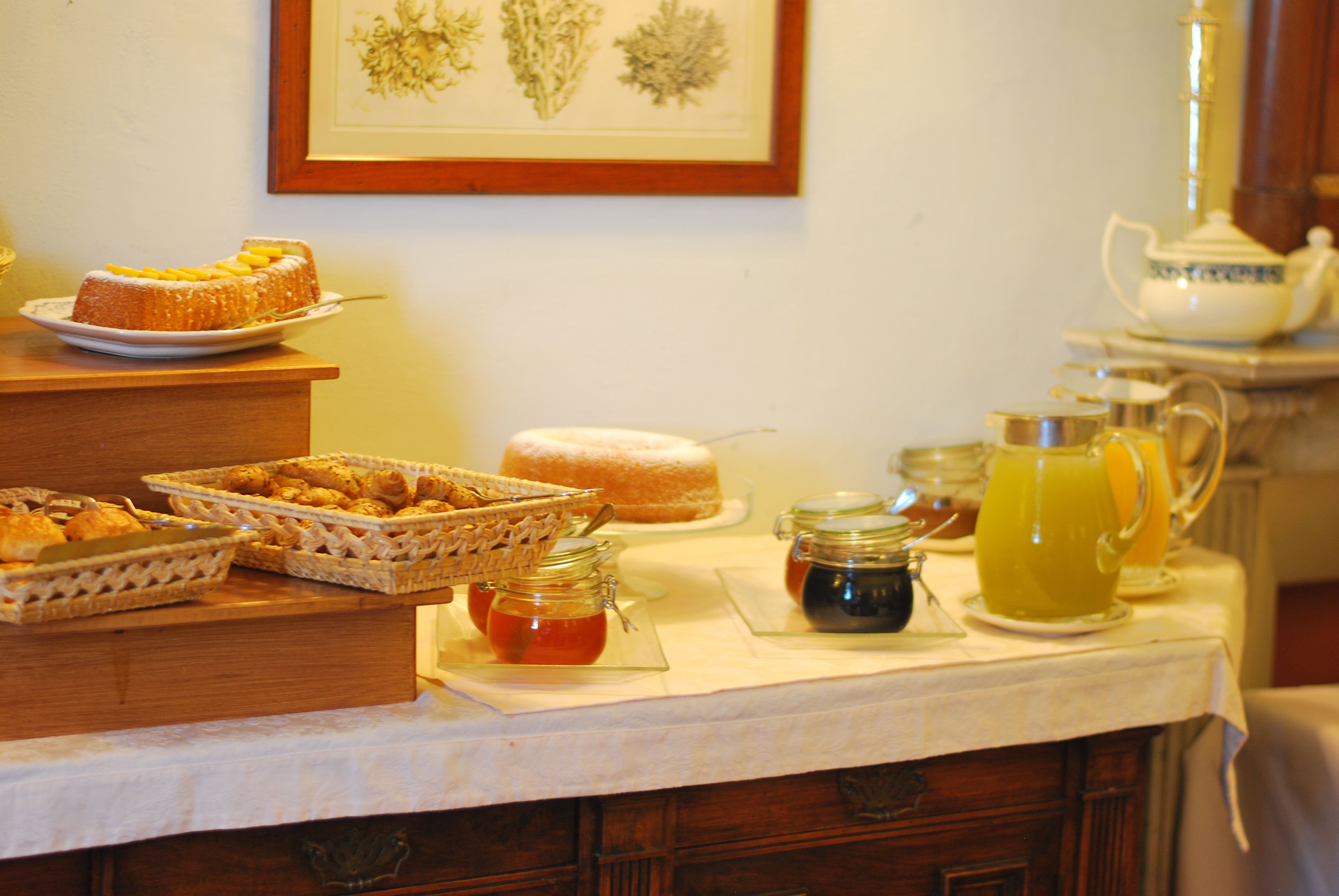 Une table de buffet proposant divers plats, notamment un gâteau, des pâtisseries et des condiments.