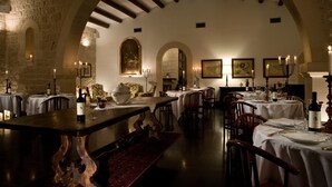 Un restaurante con varias mesas, velas y cuadros en las paredes.