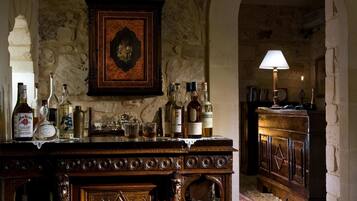 Una zona de bar con pared de piedra, un mueble de madera y varias botellas.