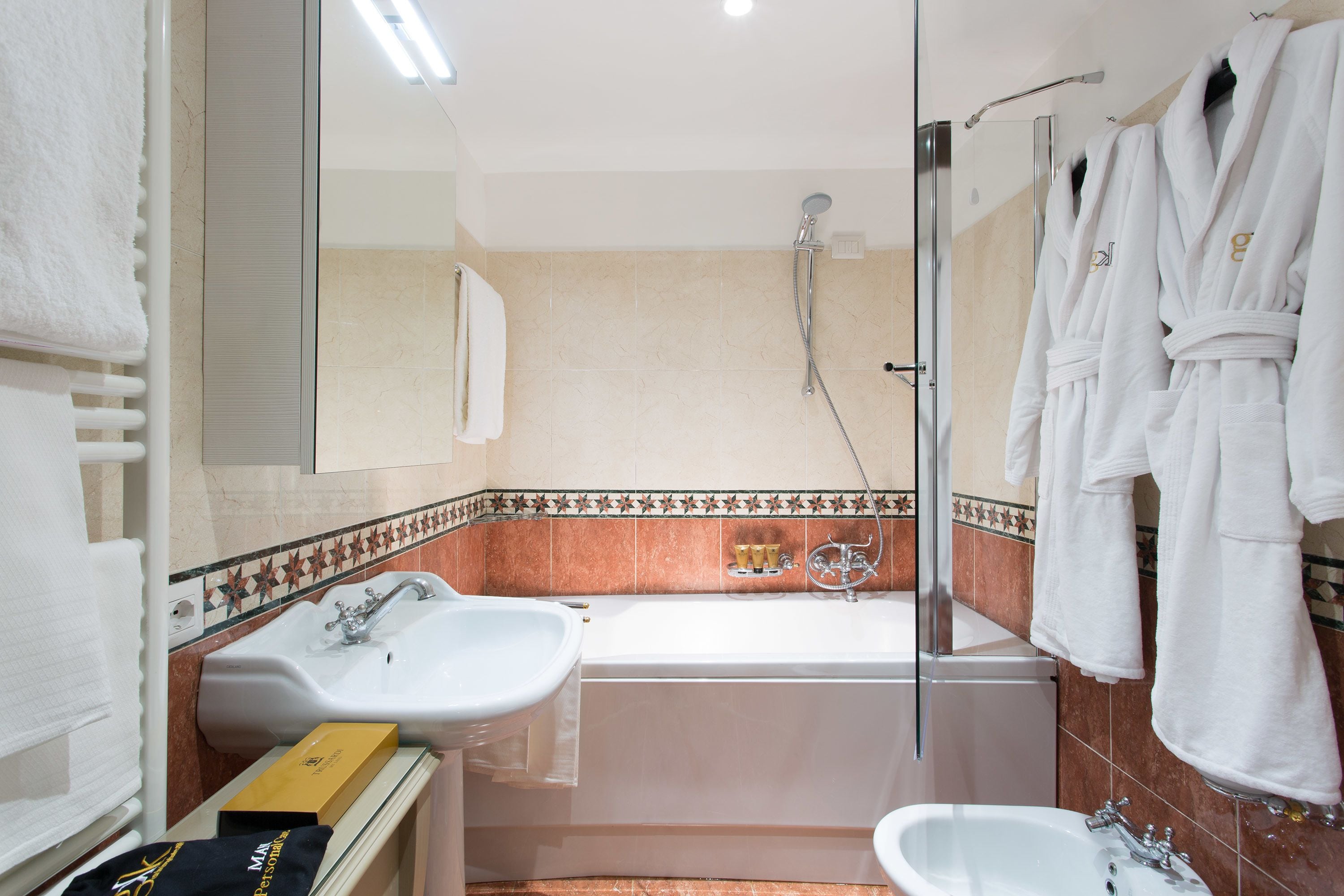 A modern bathroom with a bathtub, two sinks, and a shower.