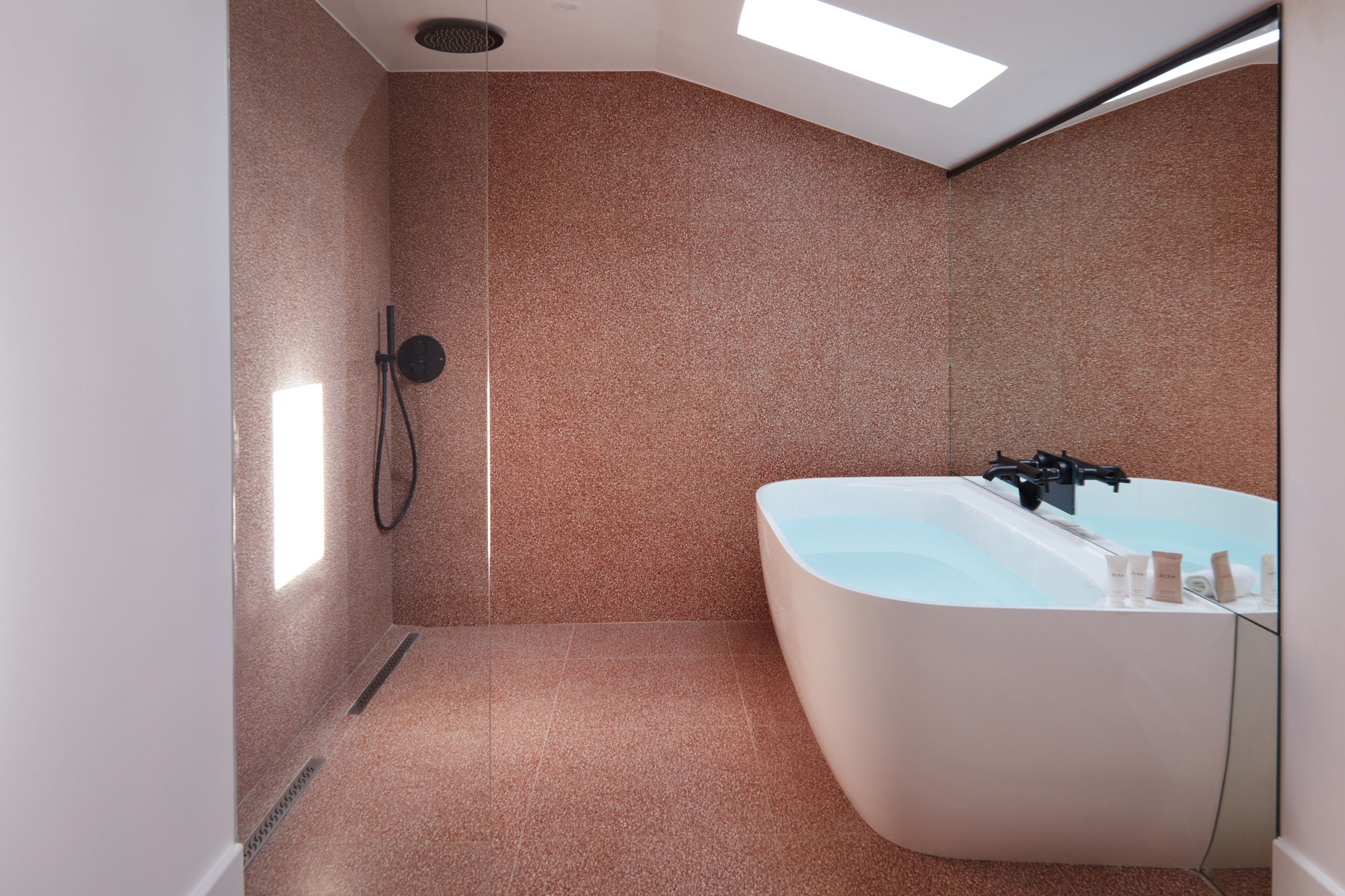 Une salle de bain moderne avec une baignoire sur pieds, un espace douche et une lucarne.