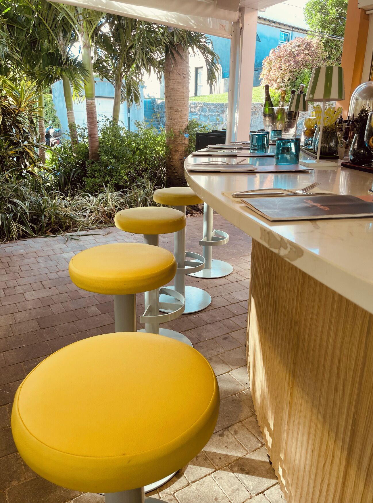 A bar area with yellow stools and a counter.