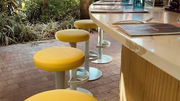 A bar area with yellow stools and a counter.