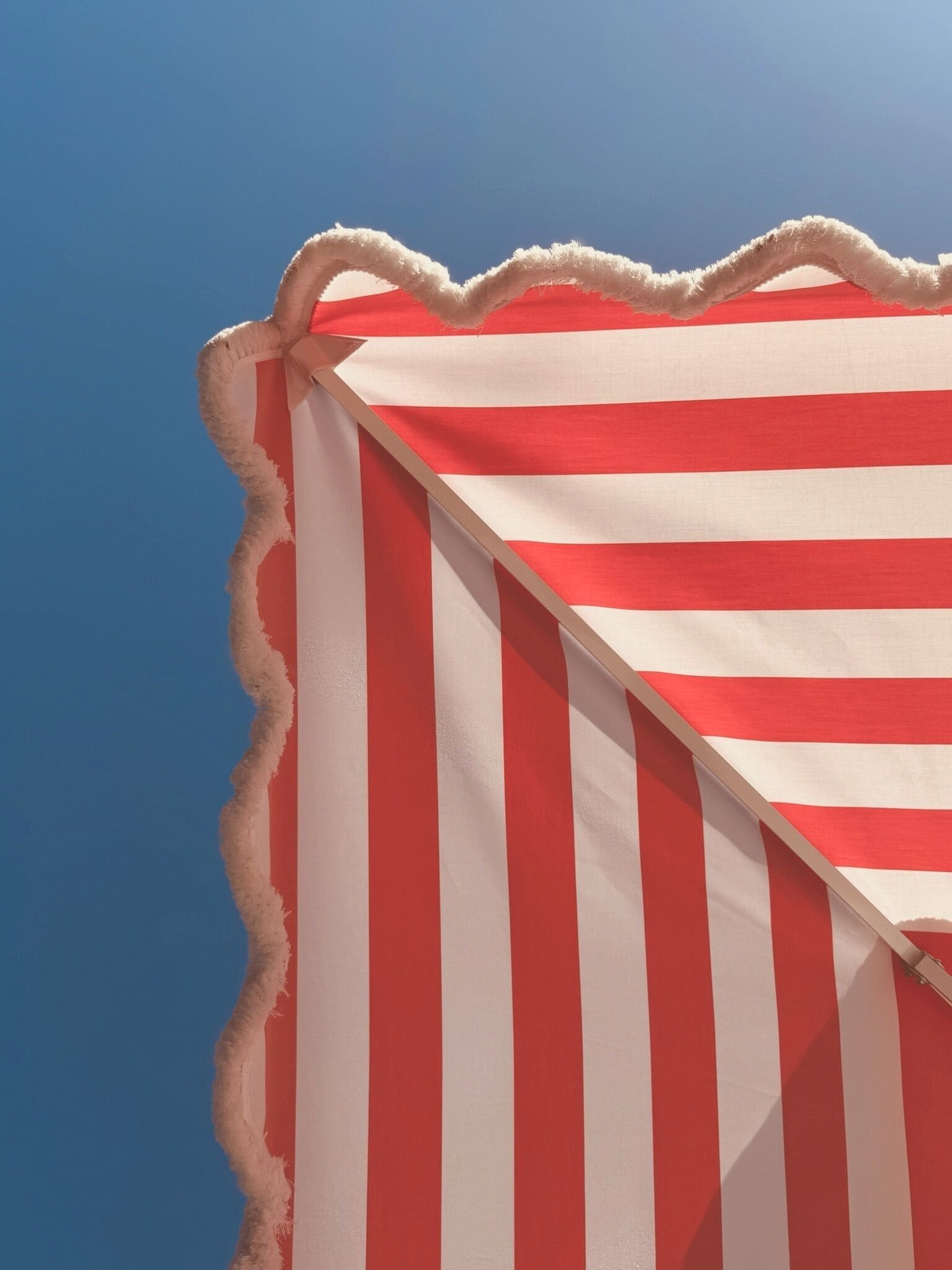 A striped beach umbrella with a white border.