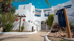 A white building with blue accents and a sign indicating room numbers. - Hotel Fiesta Beach Djerba (Djerba Midun)